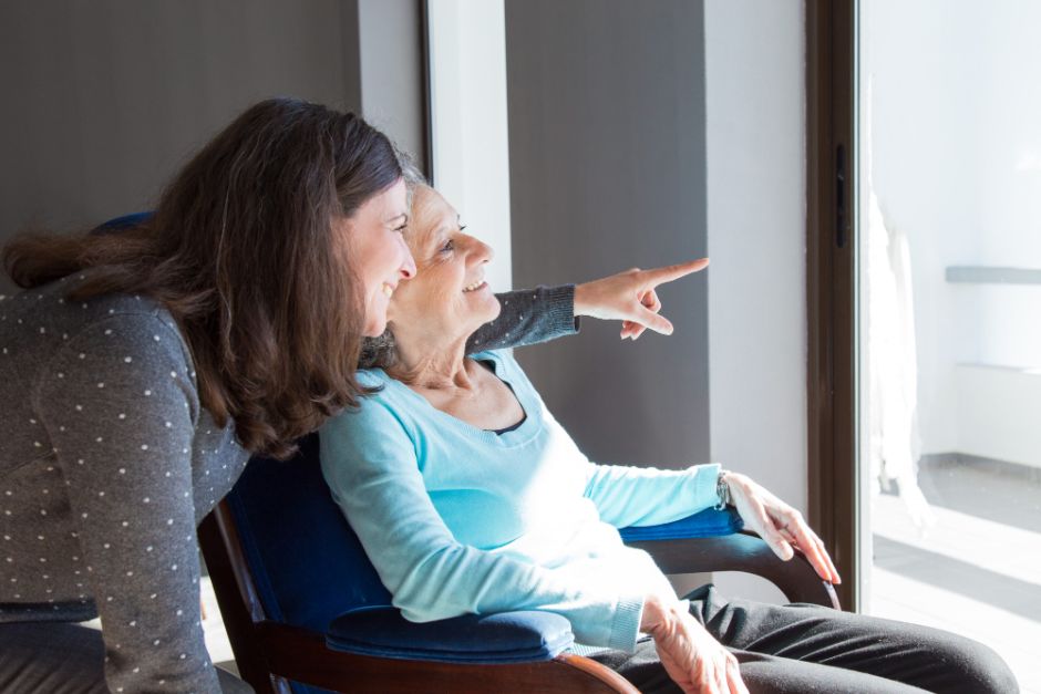 carer with woman look out window